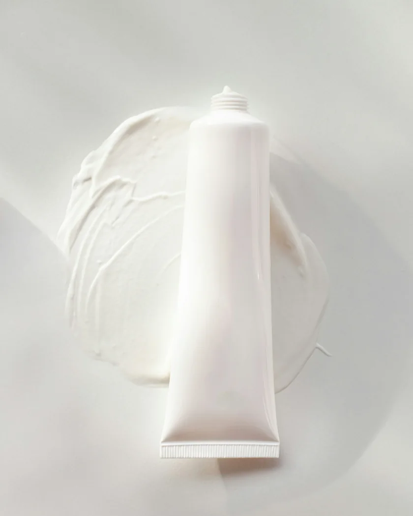 Illustrative white cream tube on a neutral surface