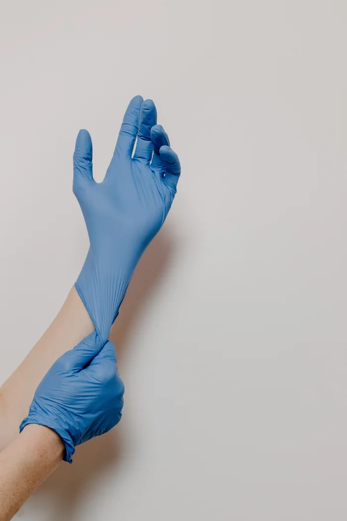 Illustrative person wearing blue disposable gloves